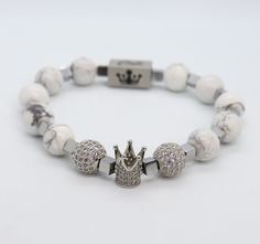 Stay calm with this Howlite gemstone bracelet. White in color with silver-plated hematite spacers along with two beautiful cubic zirconia spheres protecting a majestic cubic zirconia crown to make you feel & look like a king. This bracelet can be dressed up or down but no matter how you coordinate, this bracelet will dominate your wrist. Silver Spiritual Beaded Bracelets With Stones, Spiritual Silver Beaded Bracelets With Stones, Adjustable White Cubic Zirconia Bracelets, Luxury Silver Bracelets With Gemstone Beads, White Beaded Bracelets With Stones For Gift, Silver Beaded Bracelets With Stones, Luxury Silver Bracelet With 8mm Beads, Luxury Silver Beaded Bracelets With Gemstone, Adjustable Silver Stretch Bracelet With Gemstone