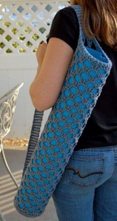 a woman carrying a crocheted blue bag on her back with the handle down