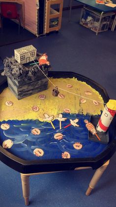 a table that has some toys on it in the shape of a boat and lighthouse