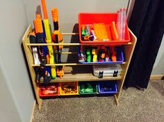 a toy shelf filled with lots of toys and construction supplies on top of carpeted floor