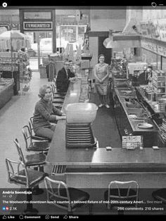 an old black and white photo of some people in a store with food on the counter