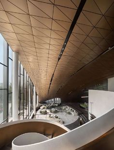 the interior of an office building with large windows and curved staircase leading up to it