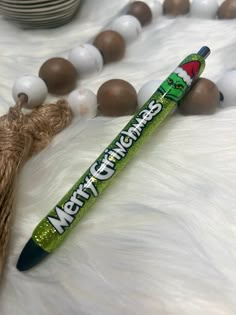 a green pen sitting on top of a white fur covered floor next to some beads