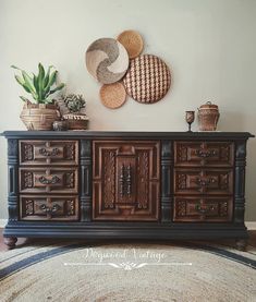 a large wooden dresser sitting on top of a rug next to a potted plant