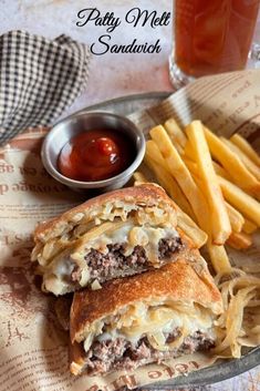 A patty melt sandwich cut in half with french fries and ketchup in the background.