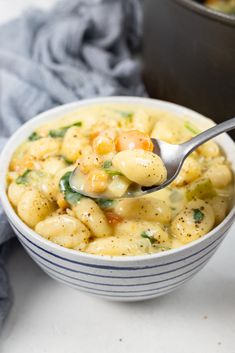 a close up of a bowl of food with a spoon in it and a cloth on the side