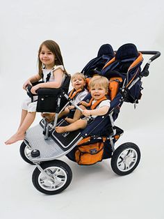 three children are sitting in a stroller