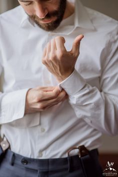 a man wearing a white shirt and blue pants is making the vulcan sign with his hands