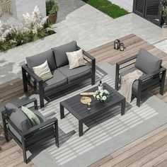 an outdoor living room with grey couches and coffee table