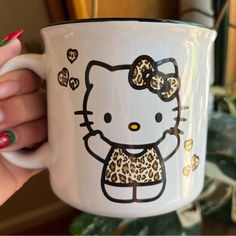 a hello kitty coffee mug with leopard print on it