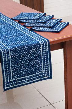 a blue table runner sitting on top of a wooden table next to a brown table