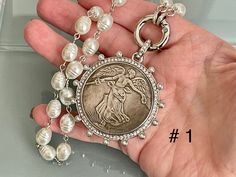 This is a gorgeous high luster, silver coin necklace. The chain is Vintage Porcelain glass pearls, There is a choice of 3 coins- Please choose from the d menu when ordering. #1.Reproduction French Commemorative Medal Coin Pendant #2.Reproduction French Madagascar Medal Coin Pendant # 3.Reproduction Morgan Peace Dollar Coin Pendant These reproduction coin pendants are surrounded by Cubic Zirconia stones and pearls. It elegantly hangs from a silver, spring lock clasp with CZ accents. The bale atta French Coins, Silver Coin Necklace, Peace Dollar, Gold Coin Necklace, Dollar Coin, Antique Inspiration, Silver Coin, Silver Spring, Coin Necklace