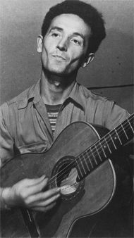 black and white photo of man playing guitar