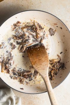 a pan filled with food and a wooden spoon