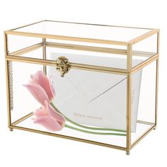 an open glass box with a pink flower in the bottom and white envelopes inside