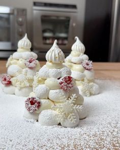 several small christmas trees made out of marshmallows and powdered sugar on a counter