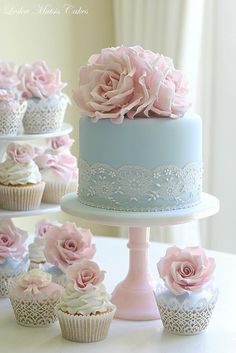 there are many cupcakes with pink flowers on the top and blue frosting