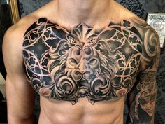 a man's chest with an intricate lion tattoo on it, and other tattoos