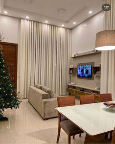 a living room filled with furniture and a christmas tree in front of a flat screen tv