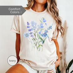 Pressed Flowers Tshirt, Boho Wildflowers Cottagecore Shirt, Oversized Vintage Botanical Tee, Pastel Floral Nature Shirt, Garden Lover Gift Embrace nature's beauty with this stunning blue flowers shirt. This Boho floral shirt is perfect for the free spirit, bringing a touch of the outdoors to your wardrobe. Whether you're a plant and gardening enthusiast or just love a good botanical tee, this Flower T Shirt is a must-have. Designed with a whimsical boho aesthetic, our Boho Flower Shirt features Spring Relaxed Fit T-shirt With Watercolor Print, Blue Casual Watercolor Print Top, Casual Blue Watercolor Print Top, Blue Casual Top With Watercolor Print, Oversized Floral Print T-shirt For Spring, Blue Watercolor Print Tops For Spring, Blue Watercolor Print Top For Spring, Cottagecore Floral Print T-shirt For Spring, Cottagecore Floral Print Short Sleeve T-shirt