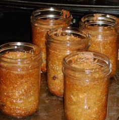 several jars filled with food sitting on top of a counter next to an oven door