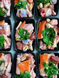 several trays filled with different types of meat and veggies on top of each other