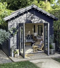 a backyard shed with patio furniture and potted plants