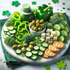 a platter filled with lots of different types of vegetables and crackers on top of green napkins