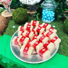 there is a platter full of red and white squares on a table with green cloth