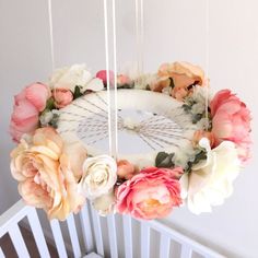 a baby crib with flowers hanging from it's sides