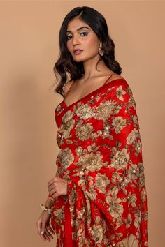 Editor's Note Featuring Varun Bahl's statement floral printed sari highlighted with intricate hand embroidery all over. It is paired with an embroidered corset red blouse. Fabric: Organza Color: Red Component: Sari, blouse and underskirt Sleeve type: Sleeveless Neckline: Sweetheart Fit: Fitted blouse Embroidery details: Hand embroidery Occasion: Festive Blouse length: 14" inches, saree: 5.5 metres, sari width: 45" inches Care: Dry Clean Only About the Designer Varun’s work marries the beauty of Varun Bahl, Cutdana Embroidery, Embroidered Corset, Blouse Embroidery, Red Floral Print, Red Saree, Fitted Blouses, Embroidery Blouse, Saree With Blouse