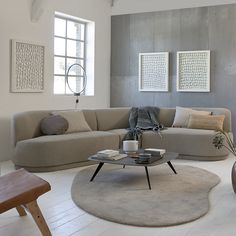 a living room with two couches and a coffee table in the middle, surrounded by art on the walls