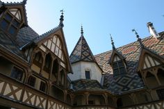 an old building with many windows and roof tiles on it's sides, looking up at the sky