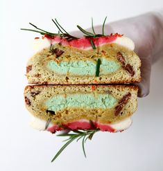 two slices of cake with frosting and sprinkles on them are being held by someone's hand