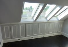 an empty room with a radiator, window and wooden floor in the corner