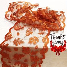 an orange and white sheer lace with flowers on it's edge is shown in front of a thank giving sign