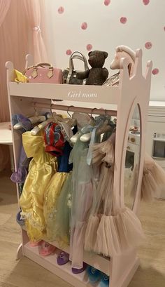 there is a toy doll rack with clothes on it