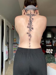 the back of a woman's body with tattoos on her upper and lower back