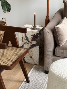 a living room filled with furniture and a candle on top of a table next to a chair