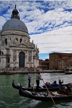 two gondolas with people on them in front of a building and some water