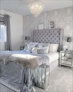 a bedroom with a large bed and chandelier