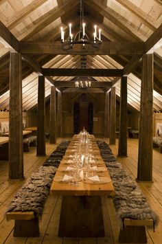 a long table is set up in the middle of a room with wooden floors and beams