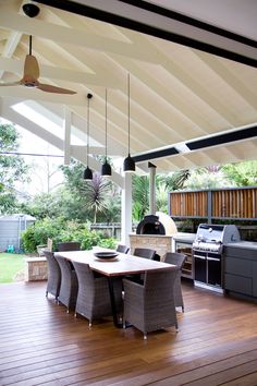 an outdoor kitchen and dining area with wood flooring