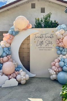 an arch made out of balloons with the moon and stars on it for a baby's first birthday