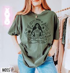 Channel your inner peace with this inspired yoga tee - featuring a hand drawn graphic of a woman with flowing shapes that celebrate movement, mindfulness, and wellness on and off the mat. We use professional quality DGT printing on all our apparel. Direct-to-garment, or DTG, is a high quality printing method that sprays ink directly onto the garment so there is no peeling or cracking. This fabulous graphic will be printed on a Comfort Colors Unisex T-Shirt. Please refer to the size charts in the images for the best fit.  Estimated Production Time: 1-5 days Estimated Shipping Time: 2-5 days 100% cotton shirt  Machine wash: cold  Non-chlorine: bleach as needed Tumble dry: low heat Iron, steam or dry: medium heat Do not dry clean Green Cotton Tops For Relaxation, Relaxation Graphic Print Crew Neck Top, Graphic Print Crew Neck Tops For Relaxation, Crew Neck Top With Graphic Print For Relaxation, Hippie Style Relaxed Fit Screen Print T-shirt, Hippie Style Relaxed Fit T-shirt With Screen Print, Green Relaxed Fit Hippie Top, Cotton Relaxed Fit Top For Meditation, Yoga Crew Neck Tops With Graphic Print