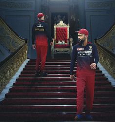 two men in red and blue outfits walking up some stairs with a throne behind them