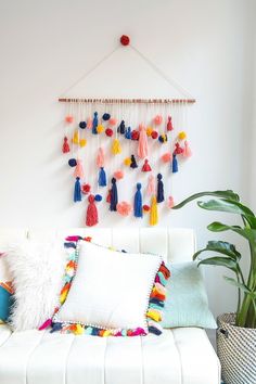 a room with a bed, potted plant and decorative wall hanging on the wall