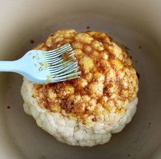 a close up of a food in a bowl with a fork on top of it