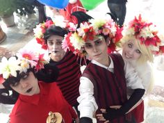 four people dressed in costumes with flowers on their heads