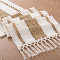 two beige and white rugs laying on top of a wooden floor